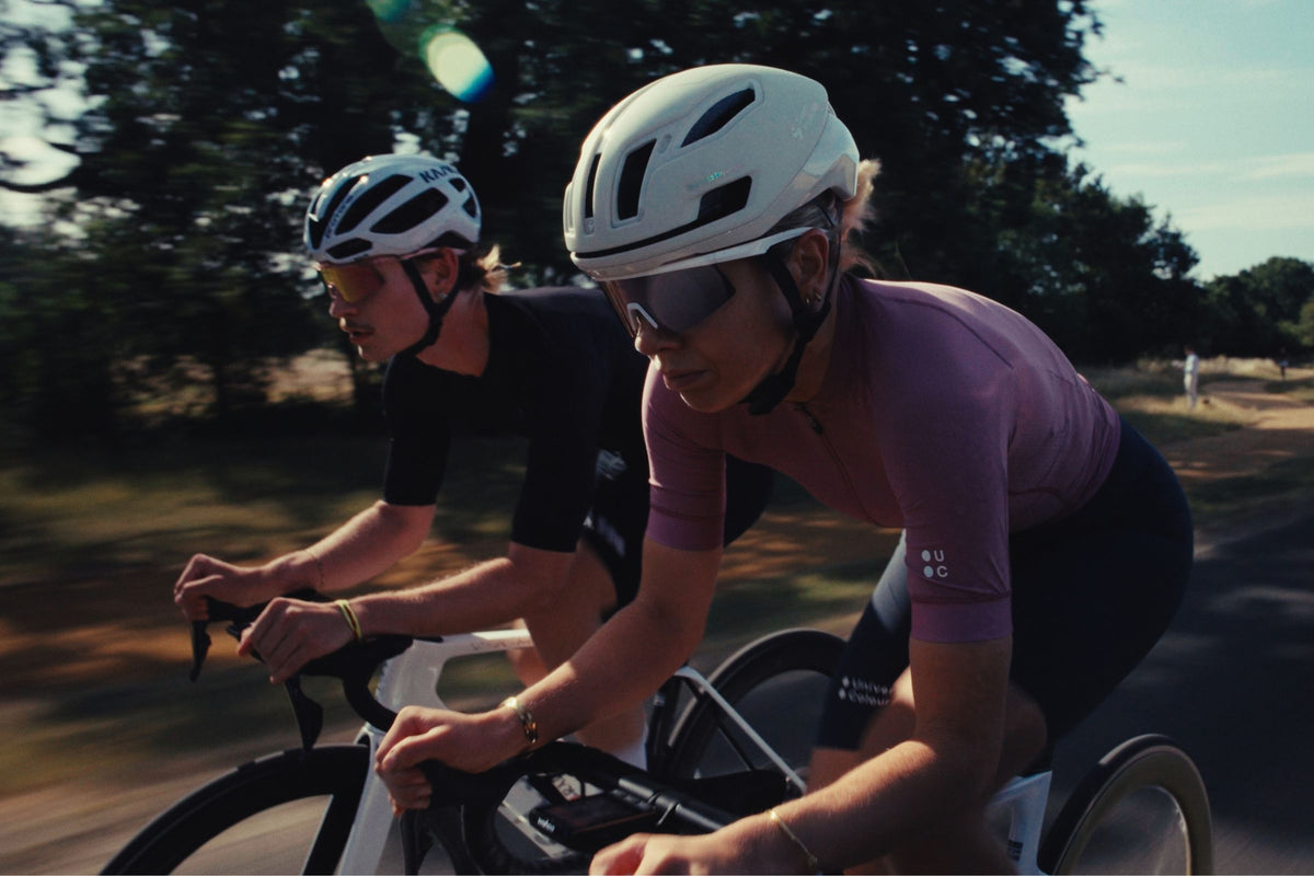 Two cyclistx in Hystride eyewear cycling in a park at pace.